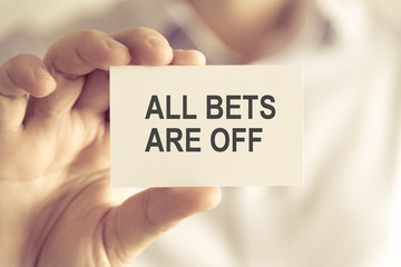 Businessman holding ALL BETS ARE OFF message card