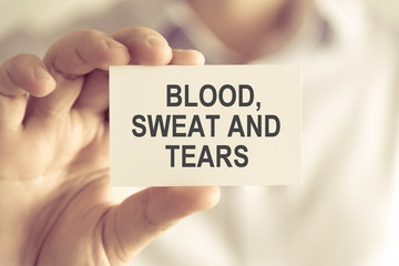 Businessman holding BLOOD, SWEAT AND TEARS message card