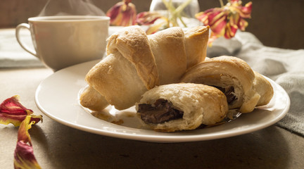 Breakfast. croissants on a white plate and coffee.