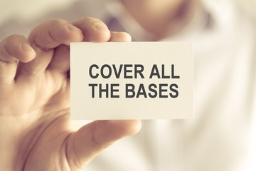 Businessman holding COVER ALL THE BASES message card