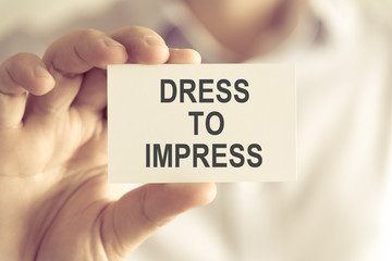Businessman holding DRESS TO IMPRESS message card