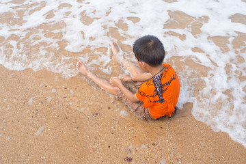boy playing on the beach in the water