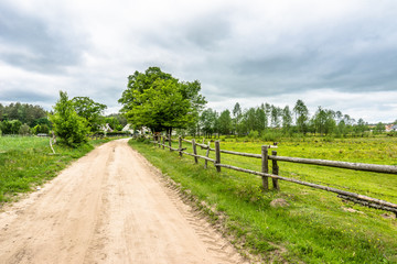 Fototapeta na wymiar Polish rural road and horse farm in the summer, landscape
