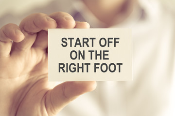 Businessman holding START OFF ON THE RIGHT FOOT message card