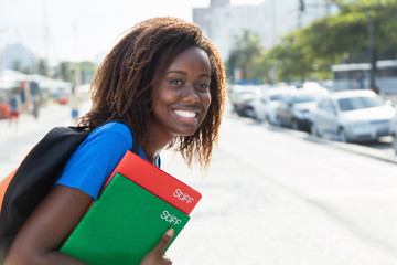 Lachende afrikanische Studentin in der Stadt