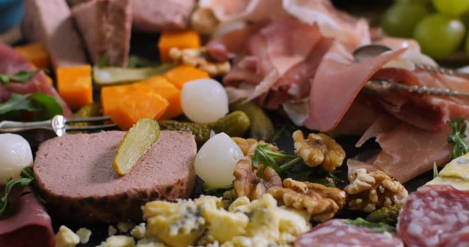 Dolly close up  push in view of a platter of cured meat (charcuterie), ham, salami, pate and cheese