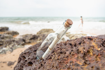 Fototapeta na wymiar Message in a bottle stuck in the rocks.