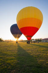 Obraz premium Two big balloon ready to take off at green field