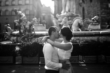 portrait of bride and groom kissing on a background of the city
