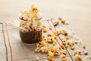 Chocolate dessert with popcorn on wooden table. Homemade cacao tasty pudding.