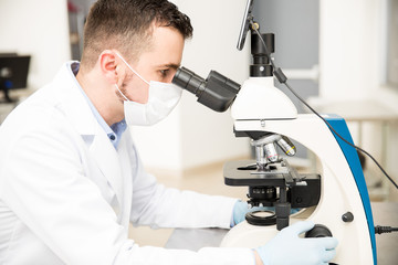 Chemist using microscope in a laboratory
