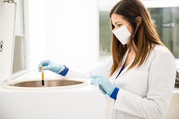 Female chemist working with a centrifuge - Powered by Adobe