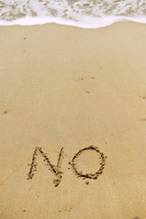 NO sign text message on the beach sand, close up
