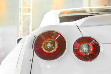 Detail on the rear light of a white sport car.