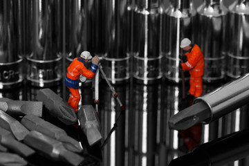 Miniature scale model construction workers with a socket set and screwdriver bits