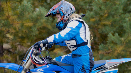 Girl mx biker - motocross racer on dirt bike at sport track