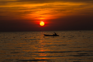 Sunset above the sea, Silhouetteon boat