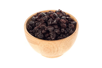 Dried raisins in wooden cup on white background.