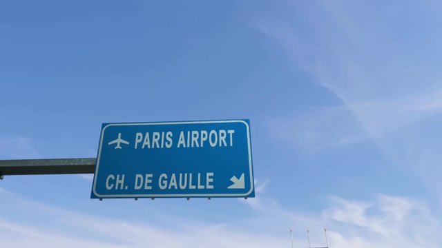 paris airport sign airplane passing overhead