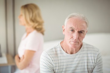 Worried senior man sitting on bed