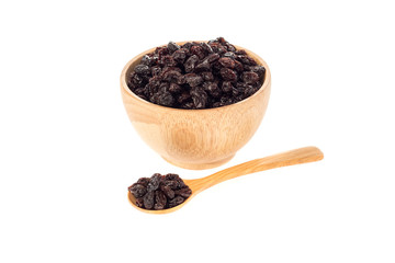 Dried raisins in wooden cup and spoon on white background.