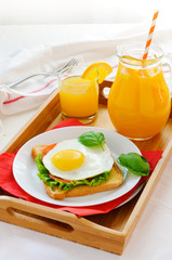 Sandwich with fried egg and orange juice