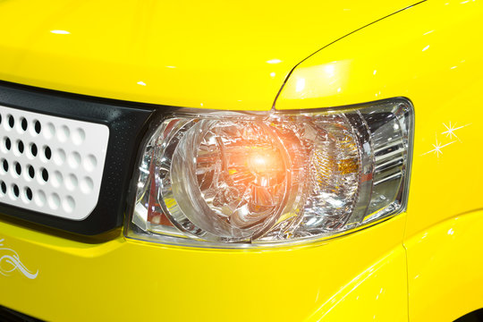 Car headlight of yellow automobile closeup © funfunphoto