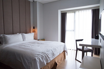 Hotel bedroom with double bed, table and TV set