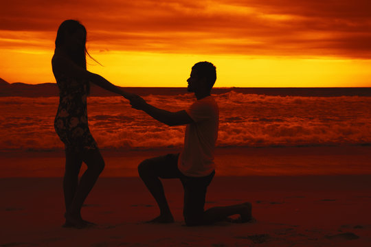 Junger Mann macht Heiratsantrag bei Sonnenuntergang