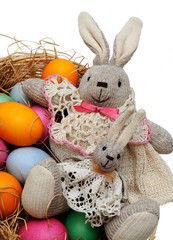 easter hares in a basket with colored eggs