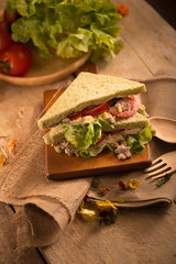 fresh made Tuna Sandwich on Wooden table in Golden Light. selective focus