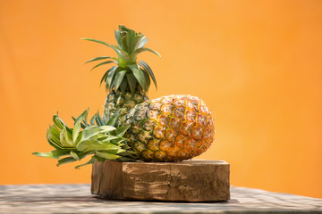 Ripe pineapple on a Orange wall background