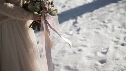 Bride with flowers outdoors at winter sunny day