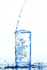 Water pours into the glass, monochromatic background, studio light