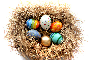 Fototapeta na wymiar Easter colorful eggs in the nest on white background.