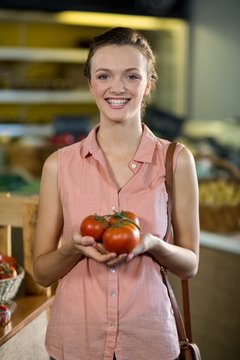 Woman holding tomatoes in grocery store