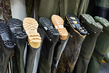 Gordijnen Rubber swamp boots for fishing in store © Sergey Ryzhov