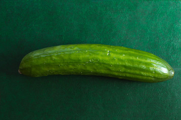 Fresh cucumber on a green board