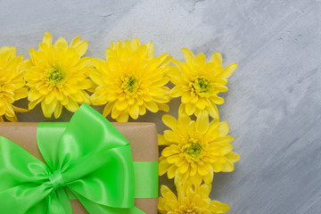 Gift box bouquet yellow chrysanthemums on grey concrete background