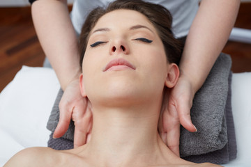 Fototapeta na wymiar Relaxing beautiful woman having a massage for her skin on a face in beauty salon 