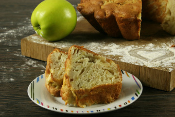 Homemade apple pie and apple with a knitted cloth on wooden table