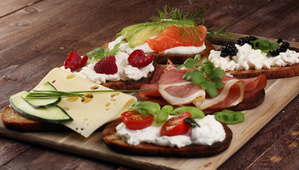 Bread Brushetta or authentic traditional spanish tapas set for lunch table. Sharing antipasti on party or summer picnic time over wooden rustic background.