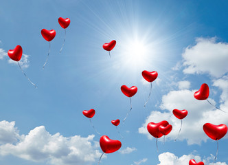 Fototapeta na wymiar Liebe verleiht Flügel: Schmetterlinge im Bauch, Himmel mit roten Luftballons in Herzform :)