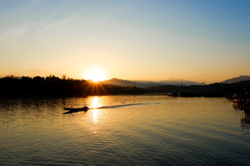 Sunrise behind mountain with boat 
