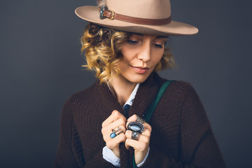 Obraz premium Fashion lifestyle portrait of sensual beautiful young woman in hat, natural beauty face, skin care, bright sexy make up, traveling mood,curly hair,stylish look,red lips,beauty make up