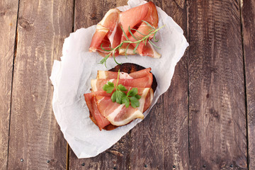 Bread with slices jamon serrano for lunch table. Sharing antipasti on party or summer picnic time...