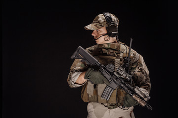 Portrait soldier or private military contractor holding sniper rifle. war, army, weapon, technology and people concept. Image on a black background.