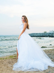Fototapeta na wymiar slender young bride in wedding dress outdoors 