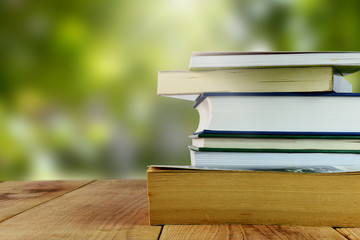 Books and blurred nature background.