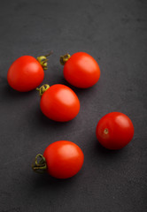 Fresh cherry tomatoes on a black matte background
